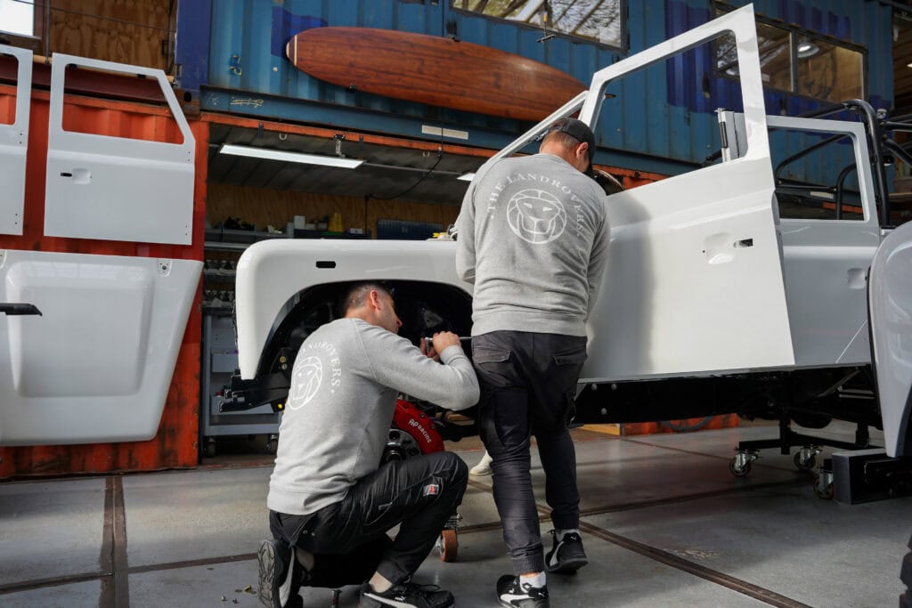 Two craftsmen from The Landrovers who are working on a classic restomod Defender