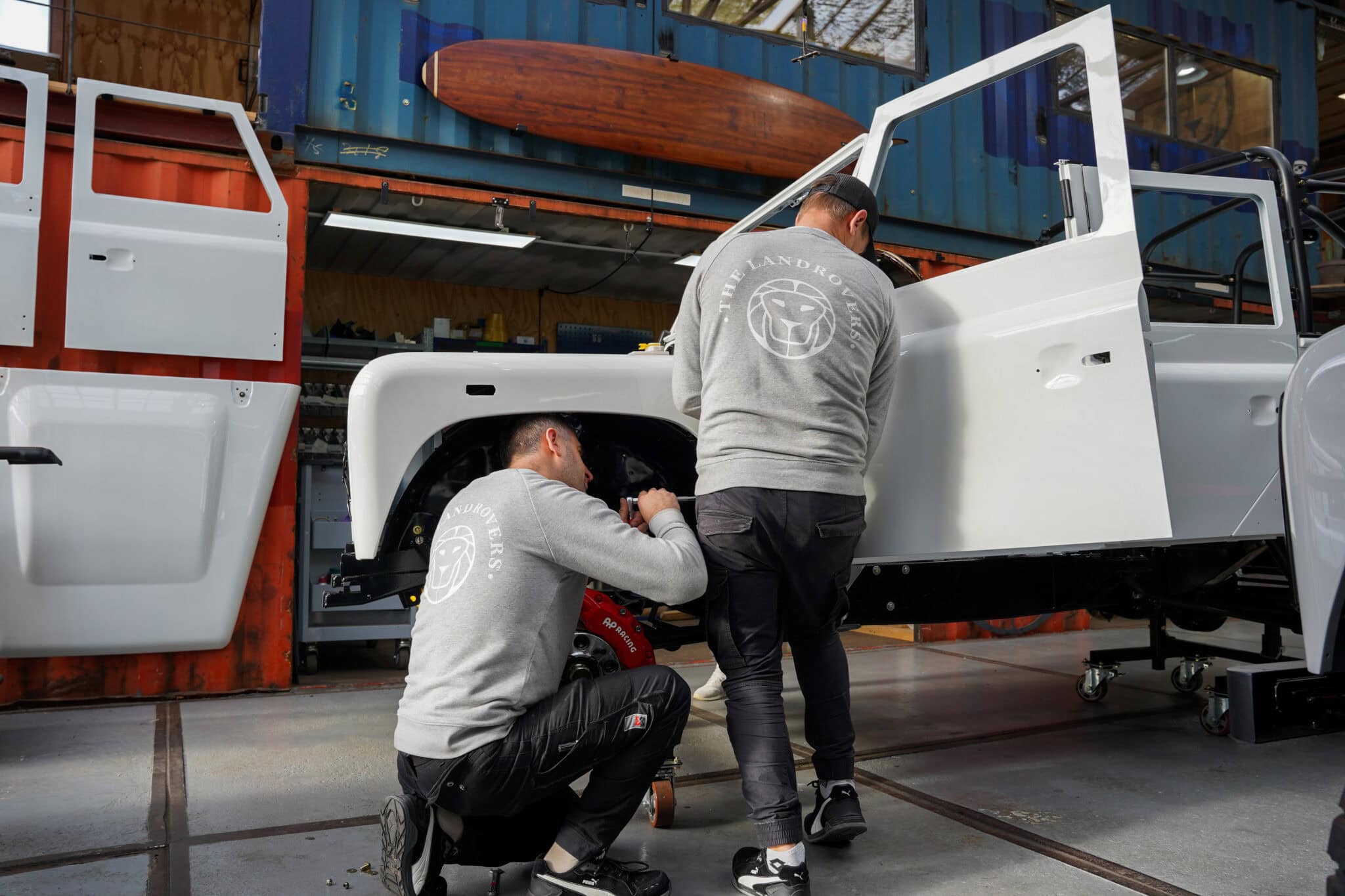 Two craftsmen from The Landrovers who are working on a classic restomod Defender