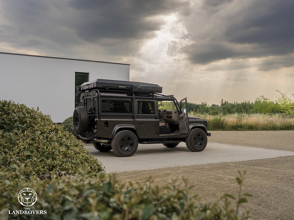 The Landrovers Defender ultra bespoke custom build in front of the garage door of a villa