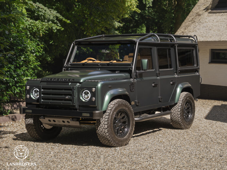 Dark green Land Rover Defender models with external roll cage.