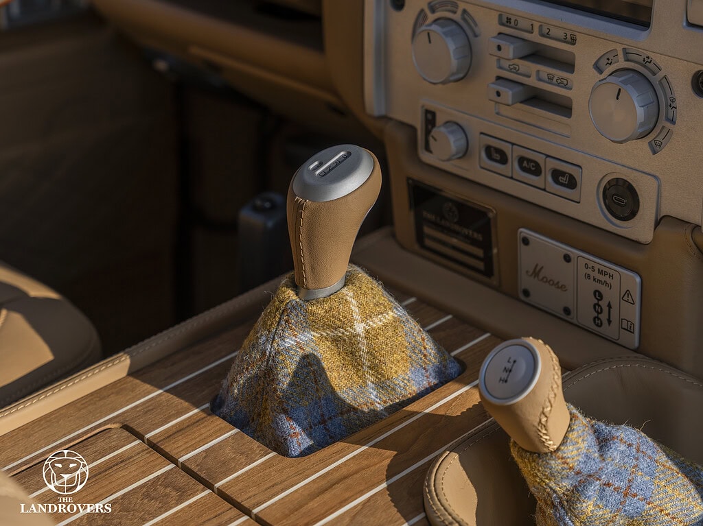 detail of the upholstery and interior with the gear lever of a bespoke Defender with Harris tweed and teak wood