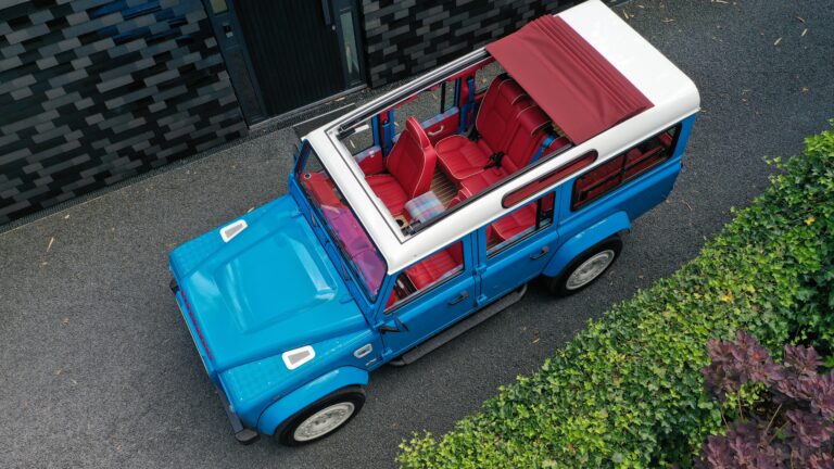 Strawberry landrover defender custom build with open sliding roof en bespoke interior