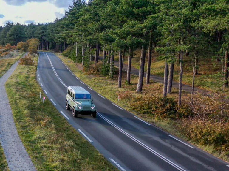 The Landrovers Defender Panterra Rica on a beatyfull road through the forest