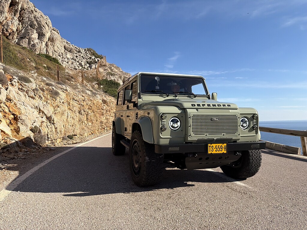 Land Rover Defender Panterra on beautifull road naxt to the sea